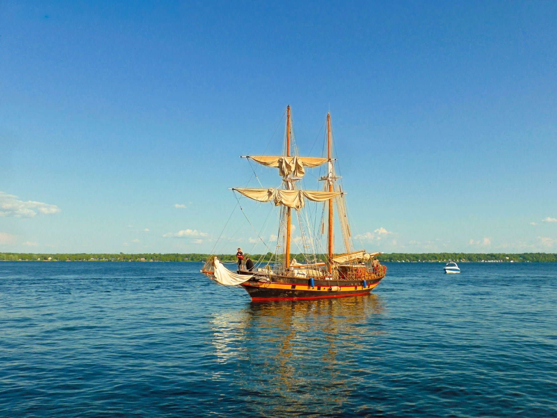 Graceful two - mast sailboat gliding beneath a flawless blue sky. - Byeutifull Art